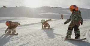 Toddlers snowboarding